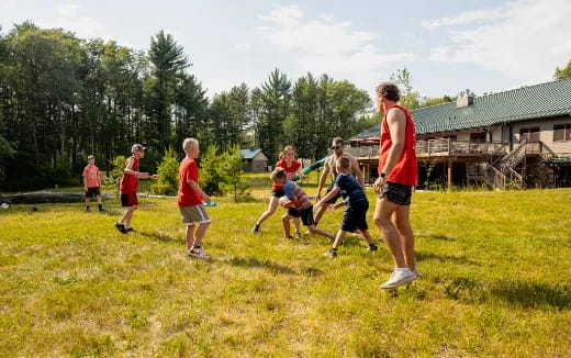 a group of people playing frisbee in a field