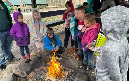 a group of children around a fire