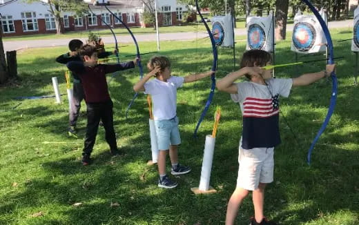 a group of kids playing with bows and arrows