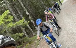 a group of people riding bikes on a road