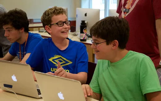 a group of boys using laptops