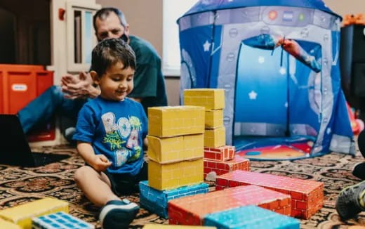 a person and a child playing with blocks