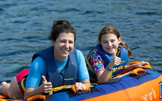a person and a girl on a raft in the water