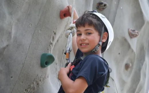 a young boy climbing a rock wall