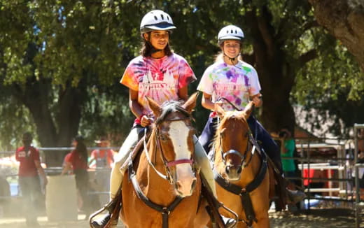a couple of women riding horses