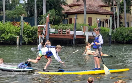 a group of people paddle on canoes