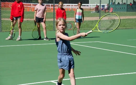 a girl holding a tennis racket