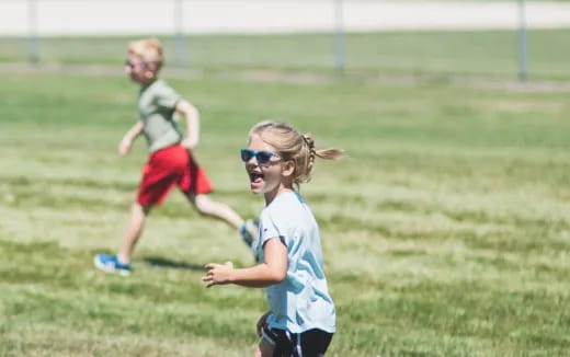 a group of kids running on a field