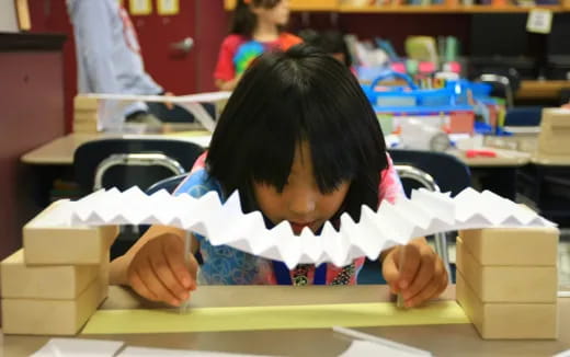 a young girl writing on a piece of paper