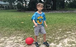 a boy playing with a ball
