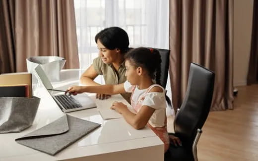 a person and a child looking at a laptop