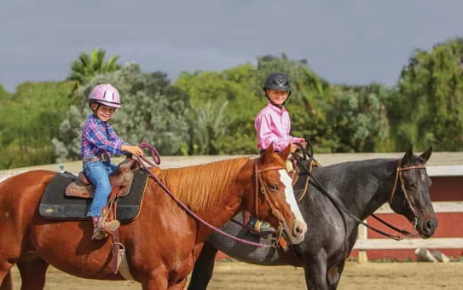 a couple of girls riding horses