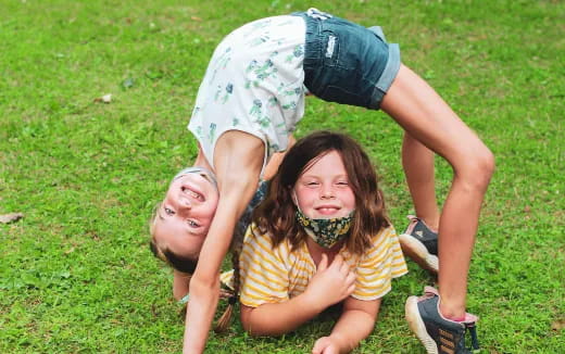 a person and a girl lying on grass