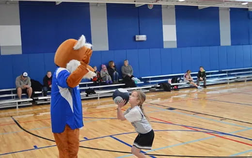 a girl and a boy playing basketball