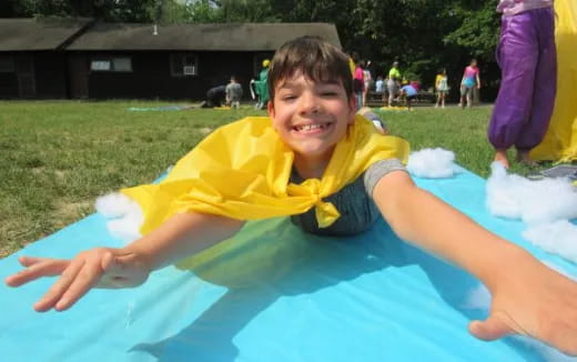 a boy in a yellow shirt on a blue trampoline
