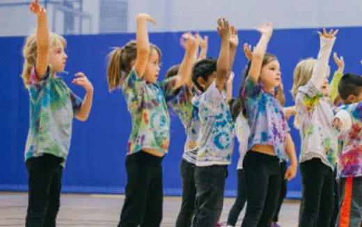 a group of children raising their hands