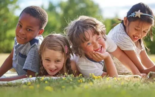 a group of children lying in the grass