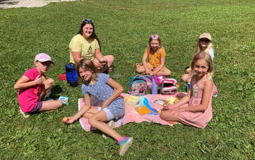 a group of people sitting on the grass