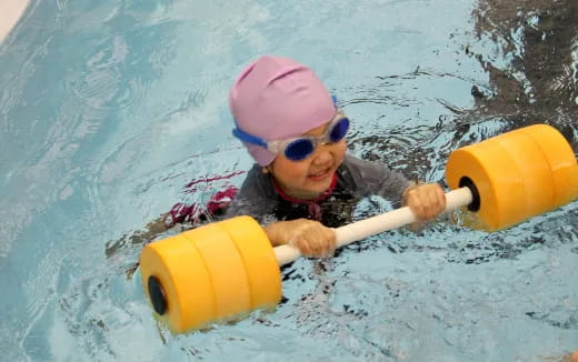 a child in a pool with a toy