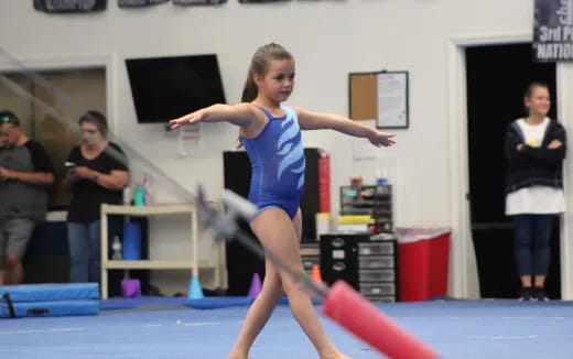a girl jumping on a mat