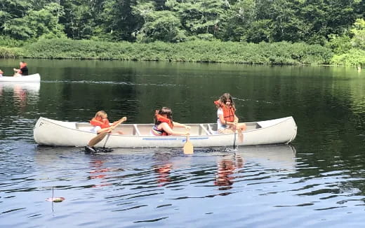 a group of people in a small boat on a lake