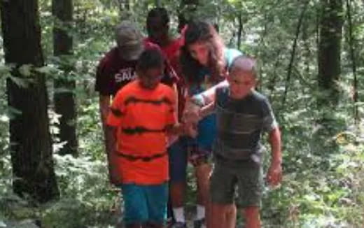 a group of people walking through the woods