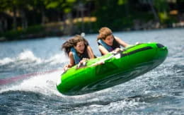 a couple of girls riding a green canoe on water