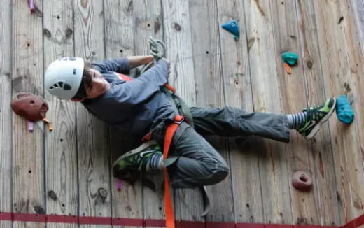 a man and a woman climbing a rock wall