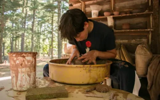 a person making a clay pot