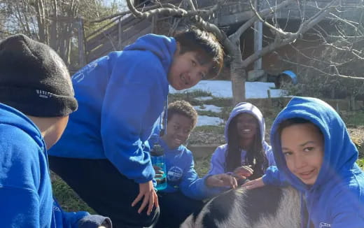 a group of people sitting on the ground with a dog