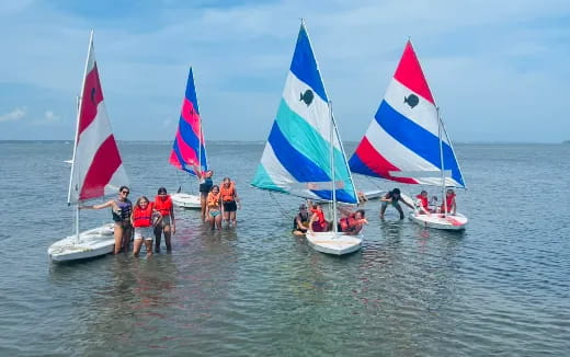 a group of people on sailboats