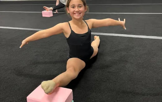 a woman in a leotard doing a handstand on a mat