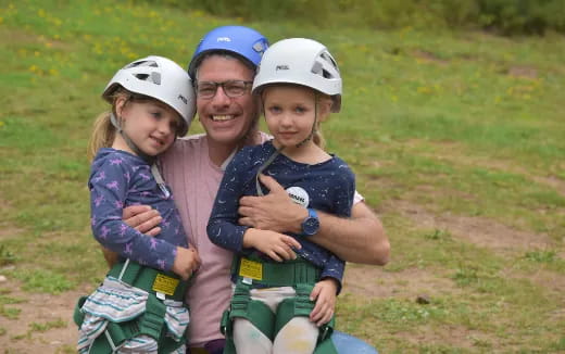 a person and two children wearing helmets