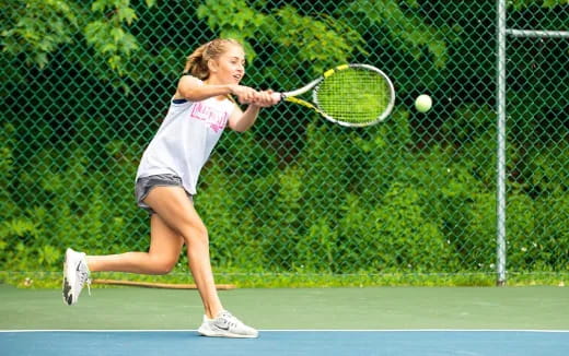 a woman hitting a ball with a tennis racket