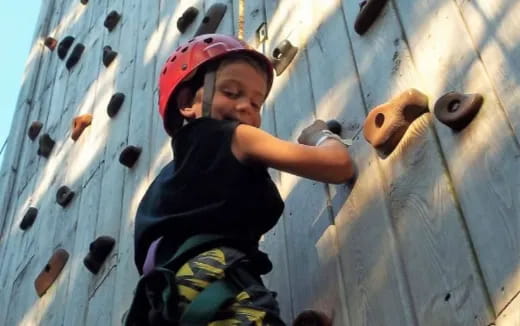 a boy climbing a rock wall