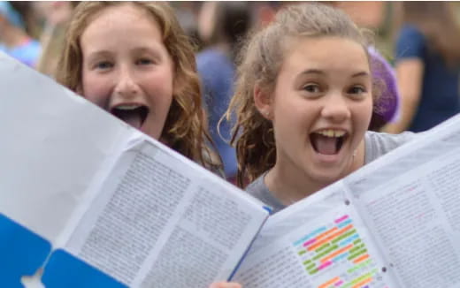 a couple of girls reading a book