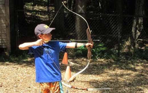 a boy holding a bow and arrow