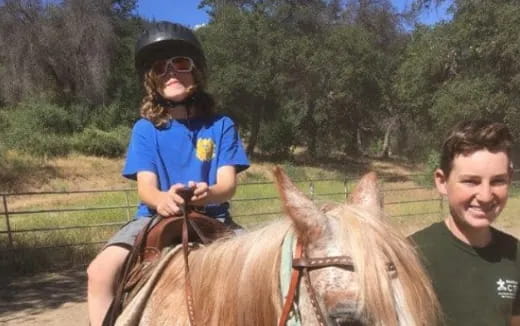 a person and a girl riding a horse