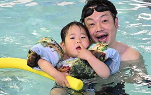 a person and a baby in a pool