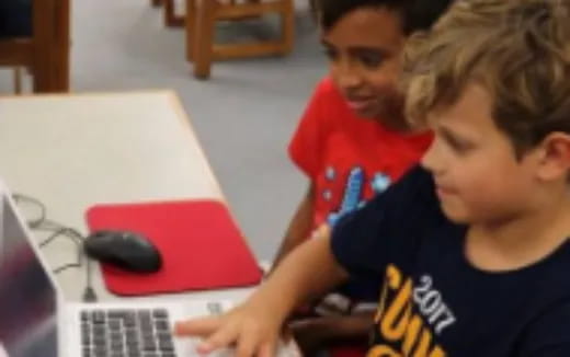 a few young boys using laptops