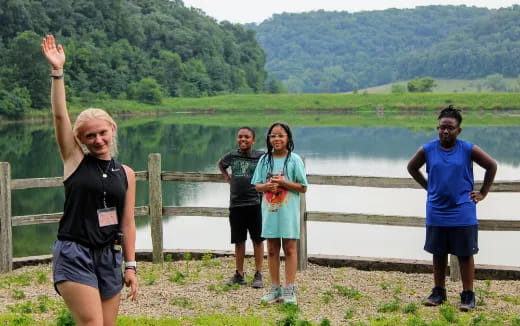 a group of people posing for a photo by a lake