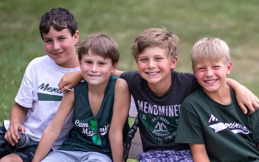 a group of boys sitting on grass