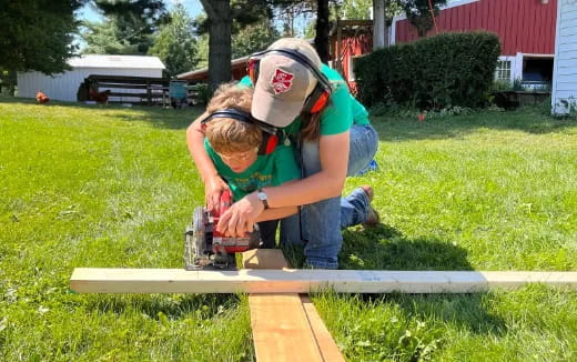 a person using a machine to cut a wood