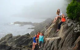 a group of people on a rocky cliff by the ocean