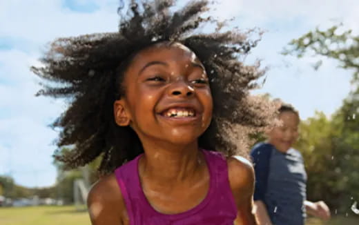 a girl smiling with a woman behind her