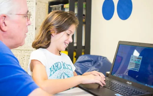 a man and a woman looking at a laptop