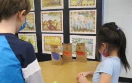 a boy and girl looking at a poster on a wall