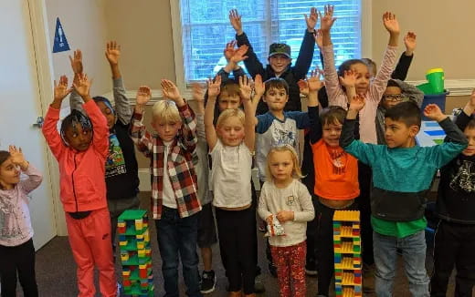 a group of children raising their hands
