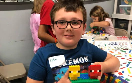a boy sitting at a table with toys