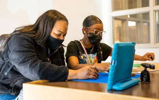a man and a woman looking at a laptop